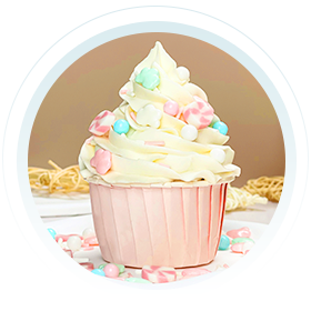 A delightful cupcake with creamy white icing, adorned with colorful cake sprinkles and candy decorations, presented in a pink liner, inviting celebration and indulgence.